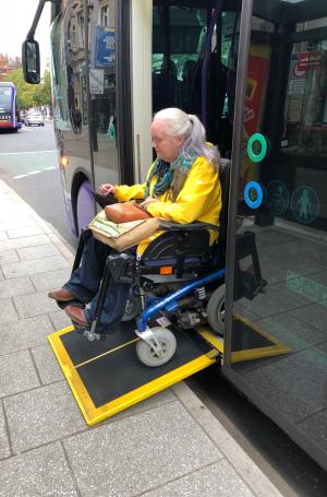 Image shows a wheelchair user exiting a Glider vehicle